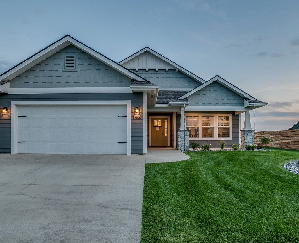 A large gray house with a white garage door