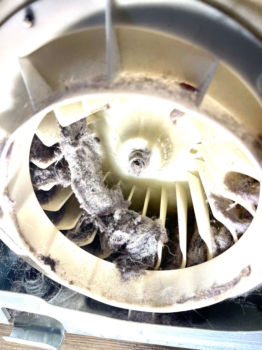 Close-up of a dusty, damaged fan blade assembly with debris lodged around the center.