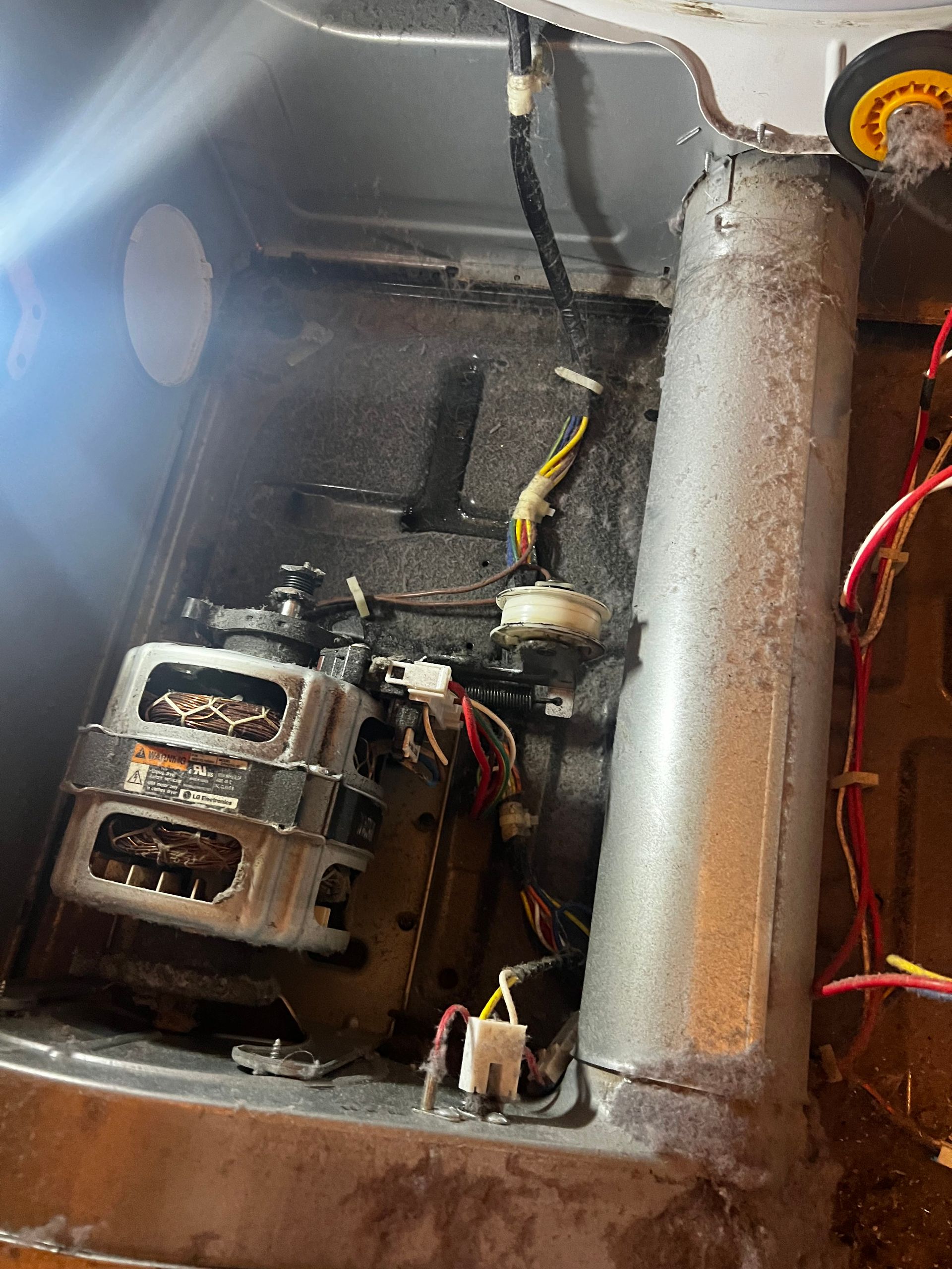 Open electrical panel with motor, wiring, and rusted metal pipe inside.