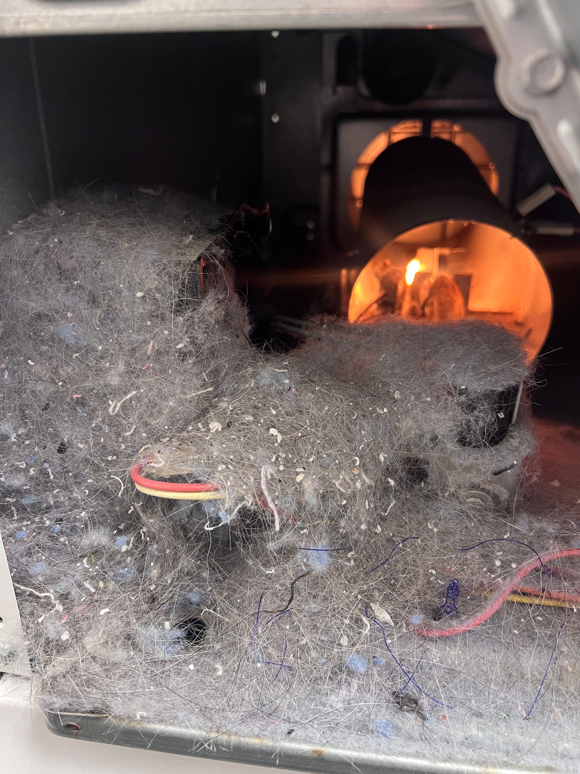 Dust-covered electrical compartment with glowing orange light inside and exposed red wires in the foreground