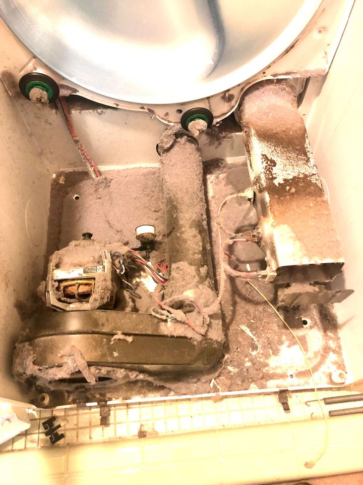 Damaged metal electrical compartment with burnt wires and residue beneath a circular fixture