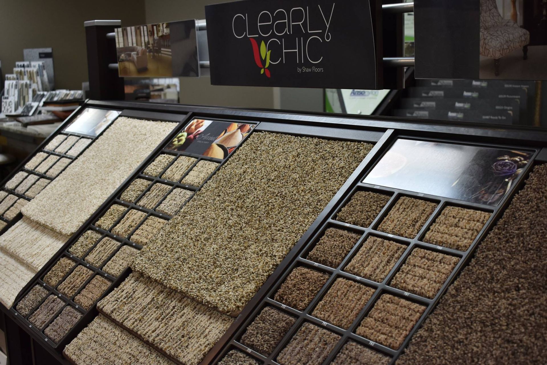 A carpet sample display rack showcasing various textures and shades of tan and brown carpet squares.