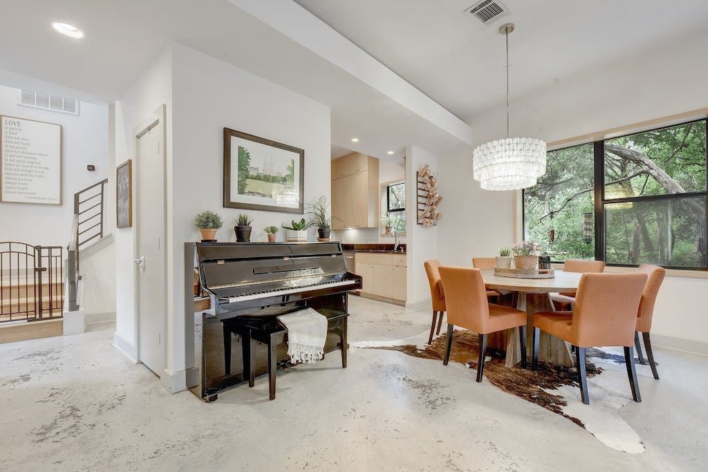 A living room with a piano and a dining table