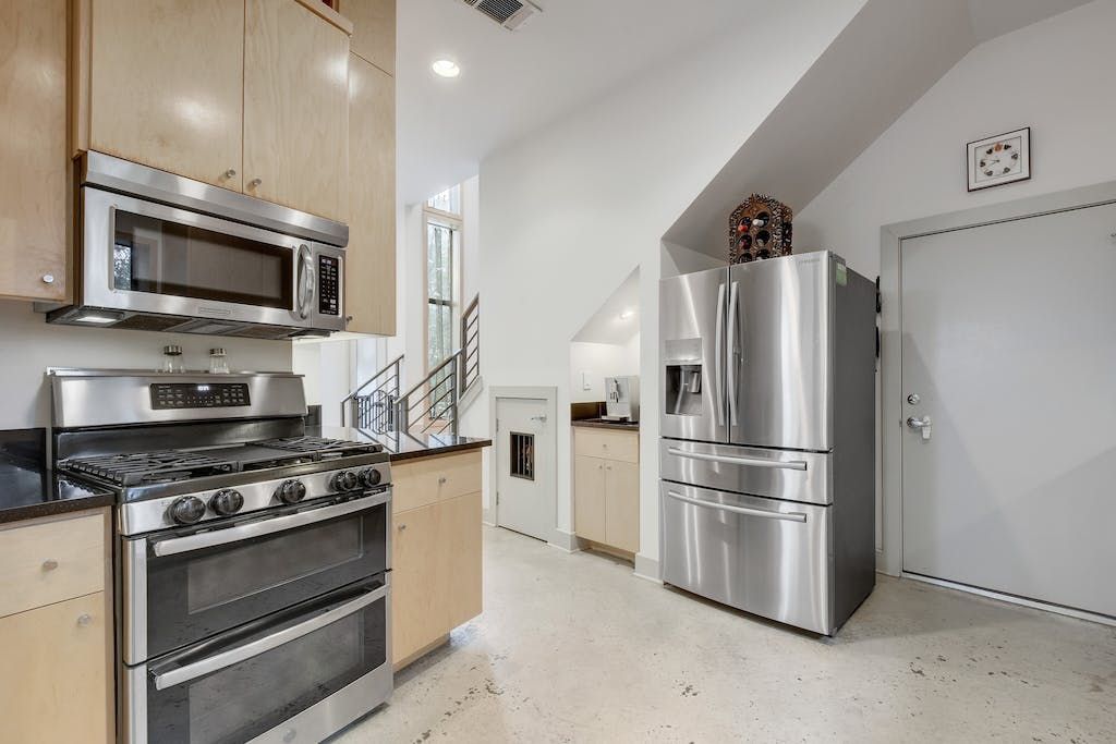 A kitchen with a stove , refrigerator and microwave