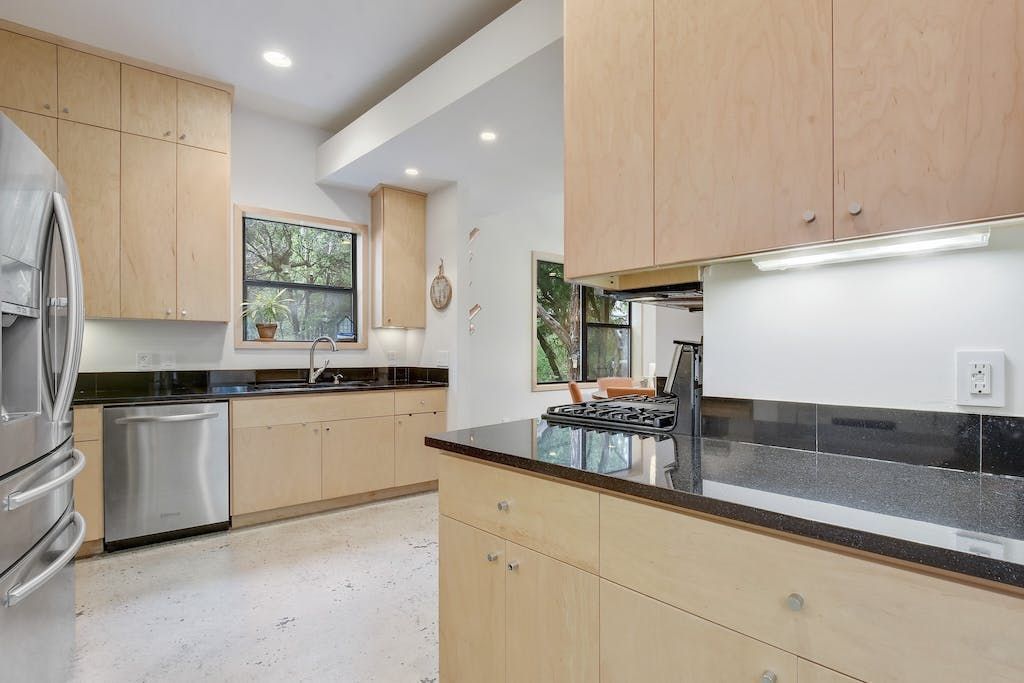 A kitchen with stainless steel appliances and wooden cabinets.