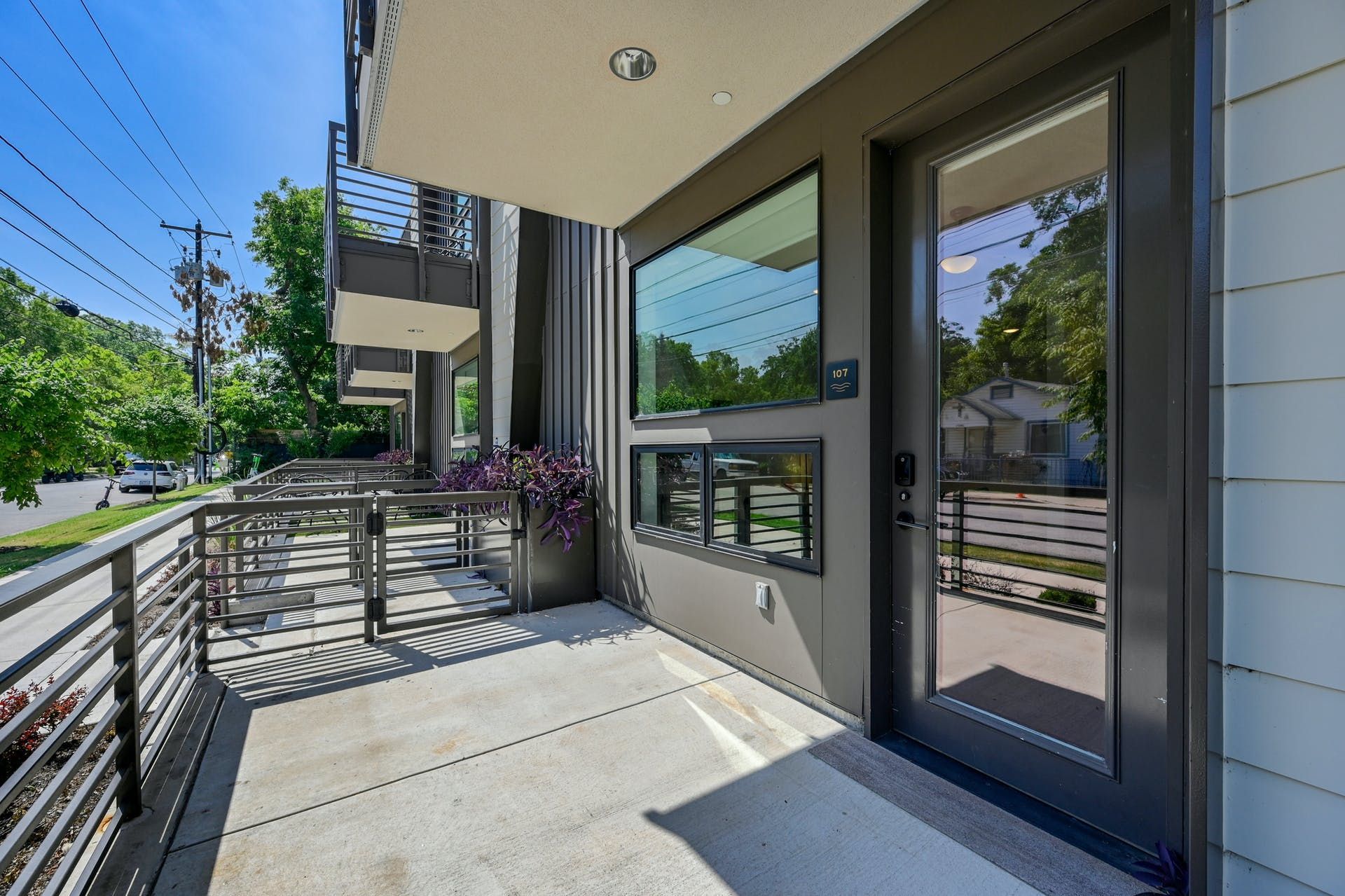 The front door of a building with a balcony and a large window.