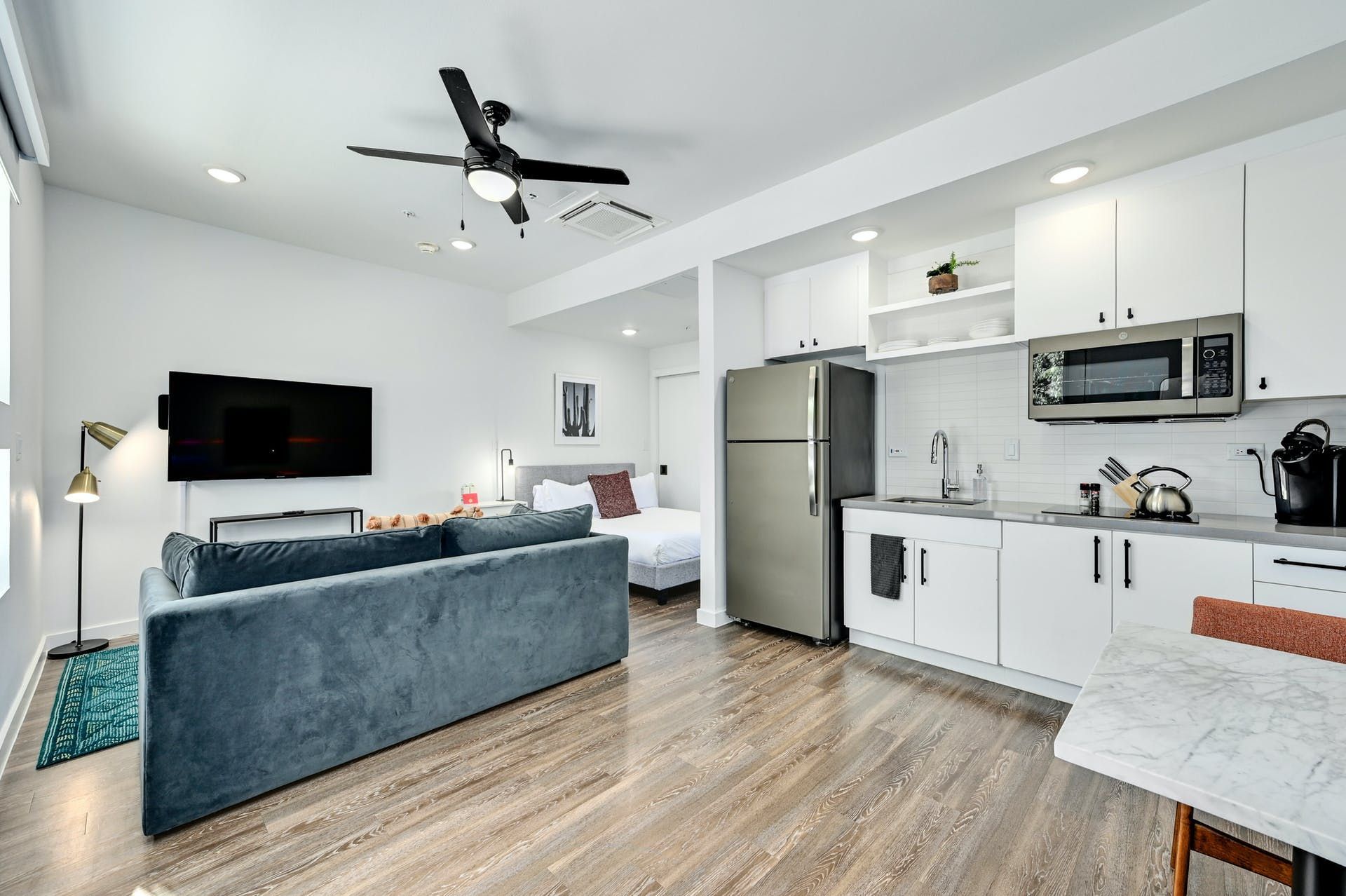 A living room with a couch , refrigerator , microwave and television.