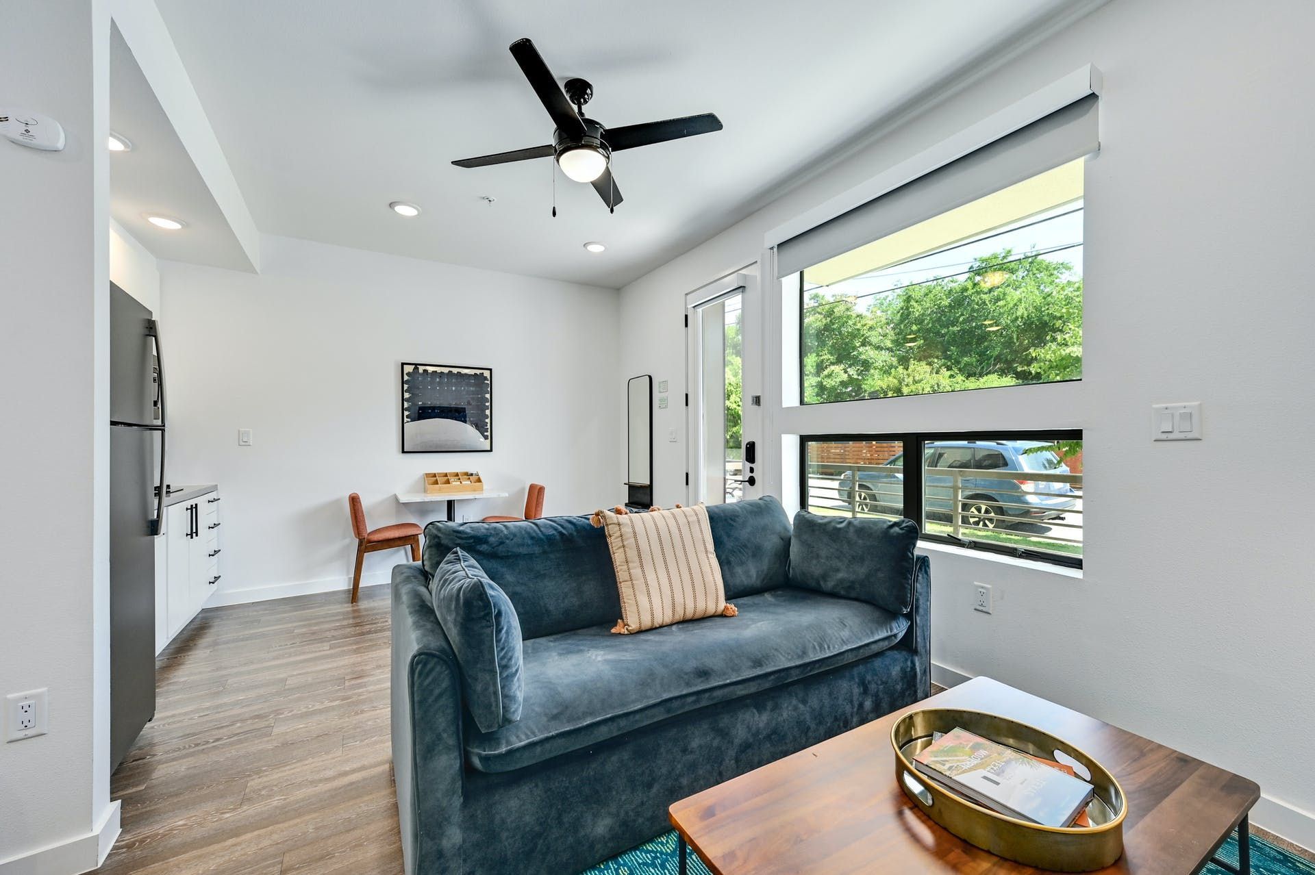 A living room with a couch , coffee table , and ceiling fan.