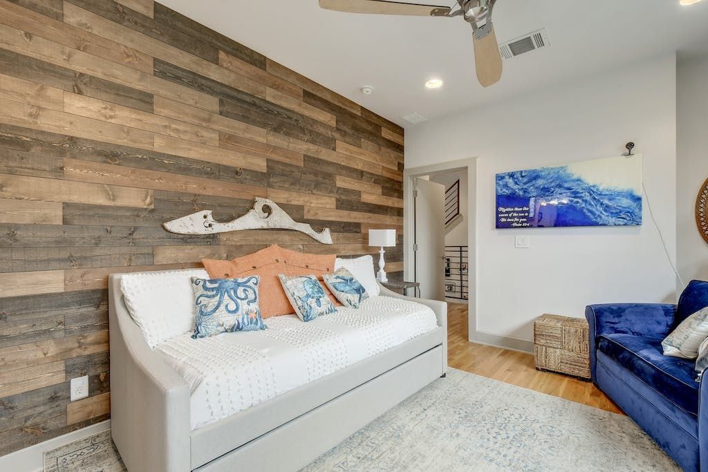 A living room with a day bed and a blue couch.