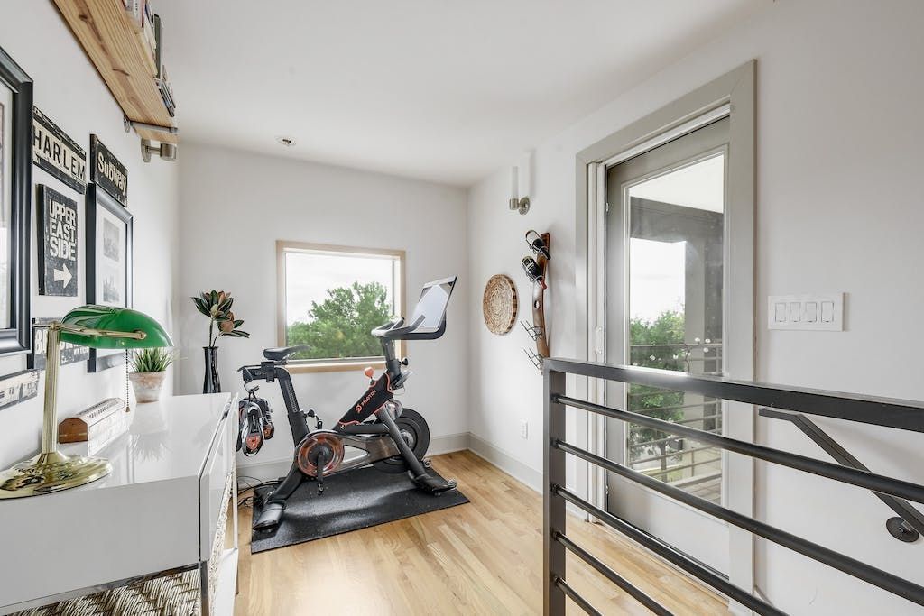 A room with a bicycle on the floor and a window.