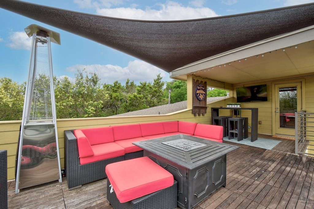 A patio with a couch and a table under a canopy.