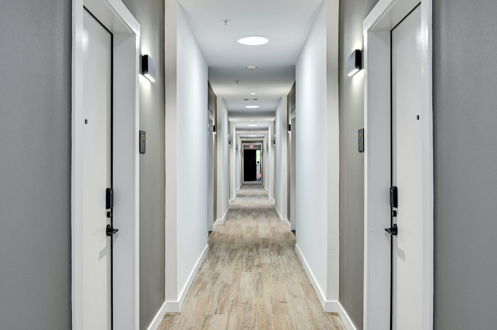 A long hallway with a lot of doors in a building.