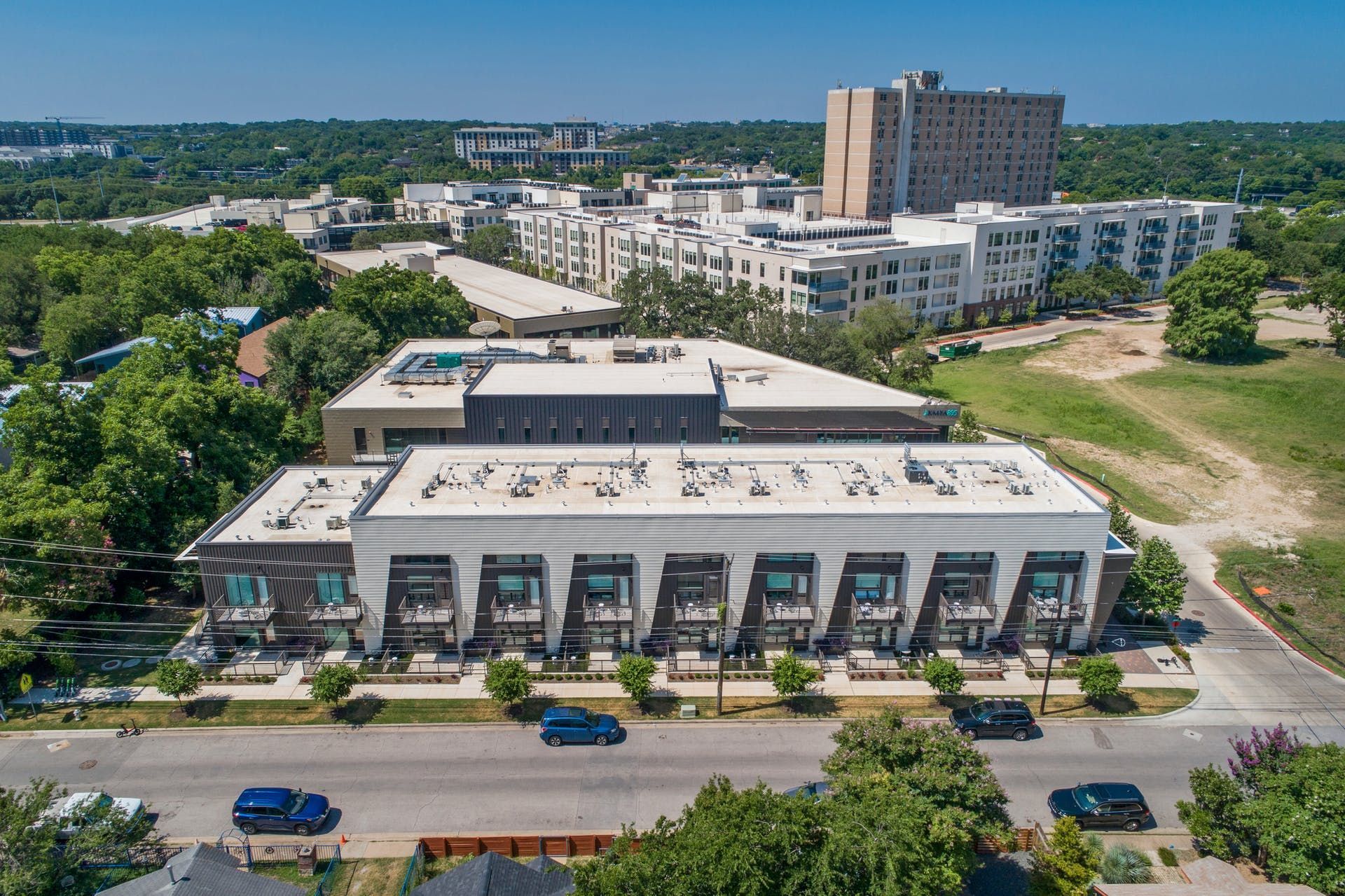 An aerial view of a large building in a city surrounded by trees.