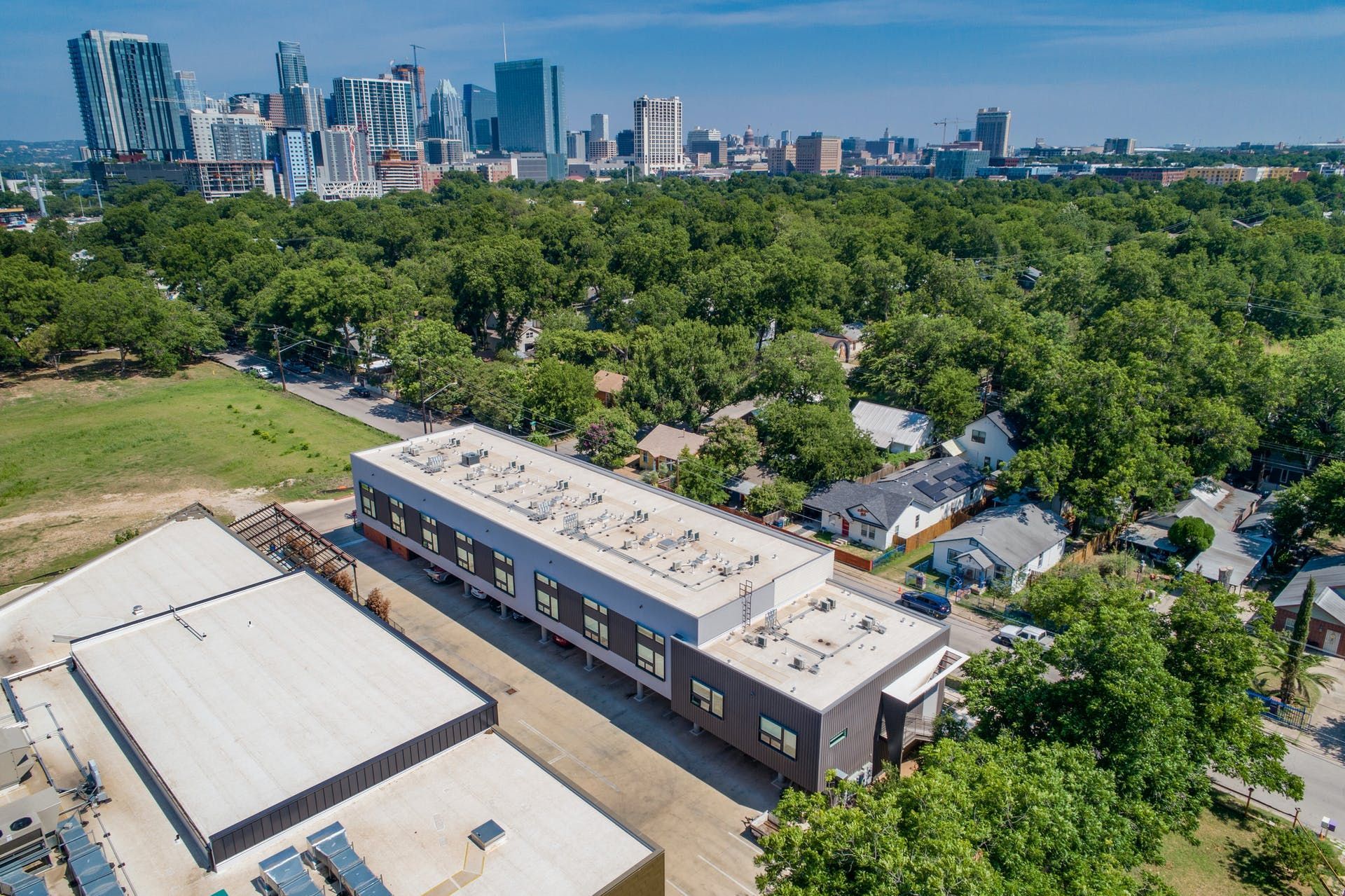 An aerial view of a building with a city skyline in the background.