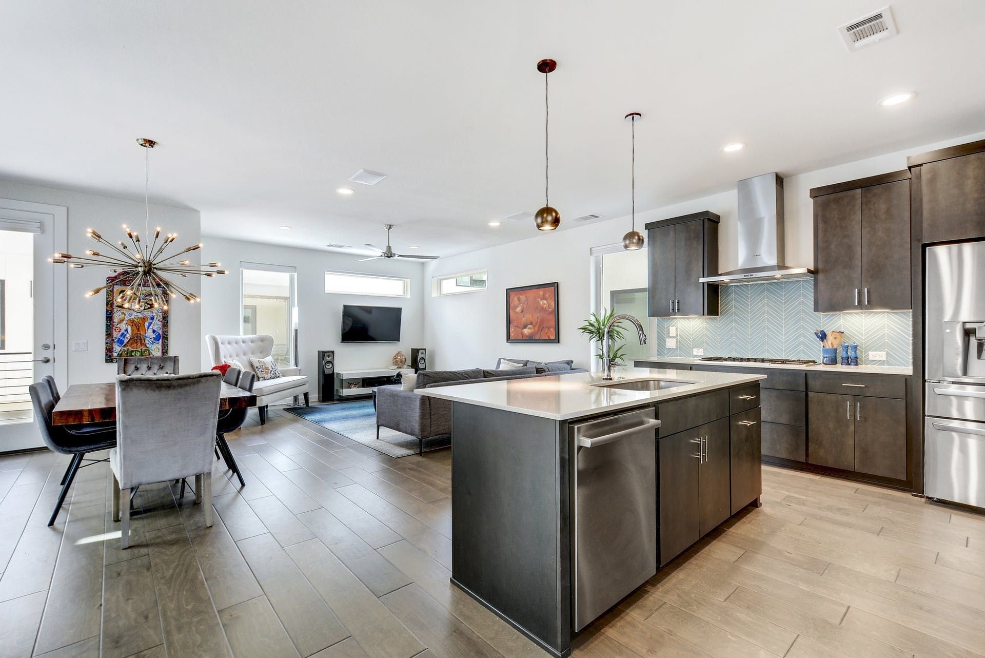 A kitchen with stainless steel appliances and a large island in the middle of the room.