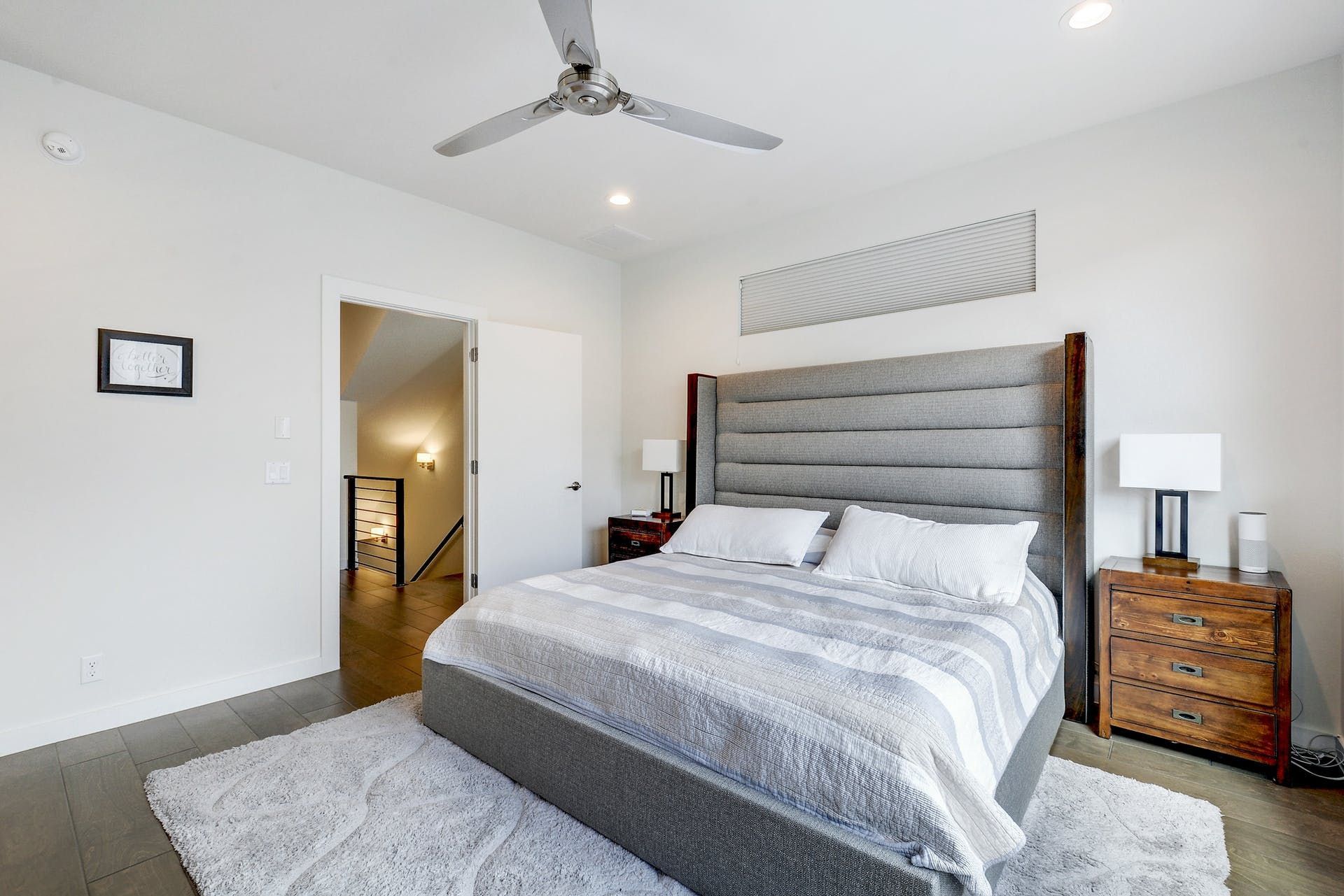 A bedroom with a large bed and a ceiling fan.