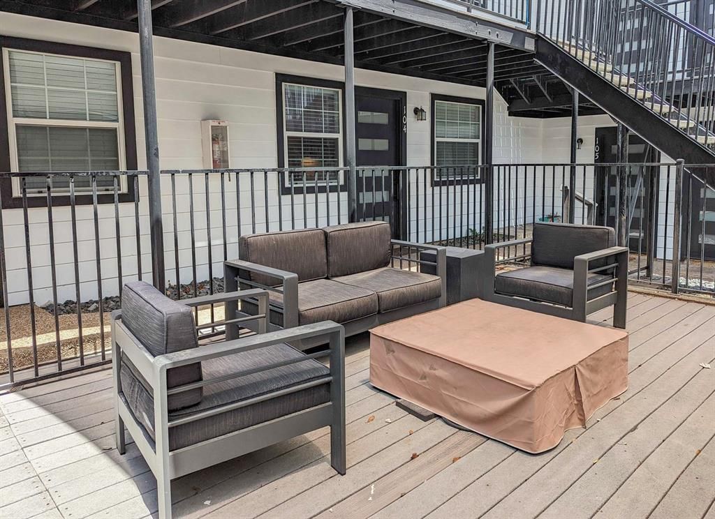 A deck with a couch , chairs , and a coffee table.