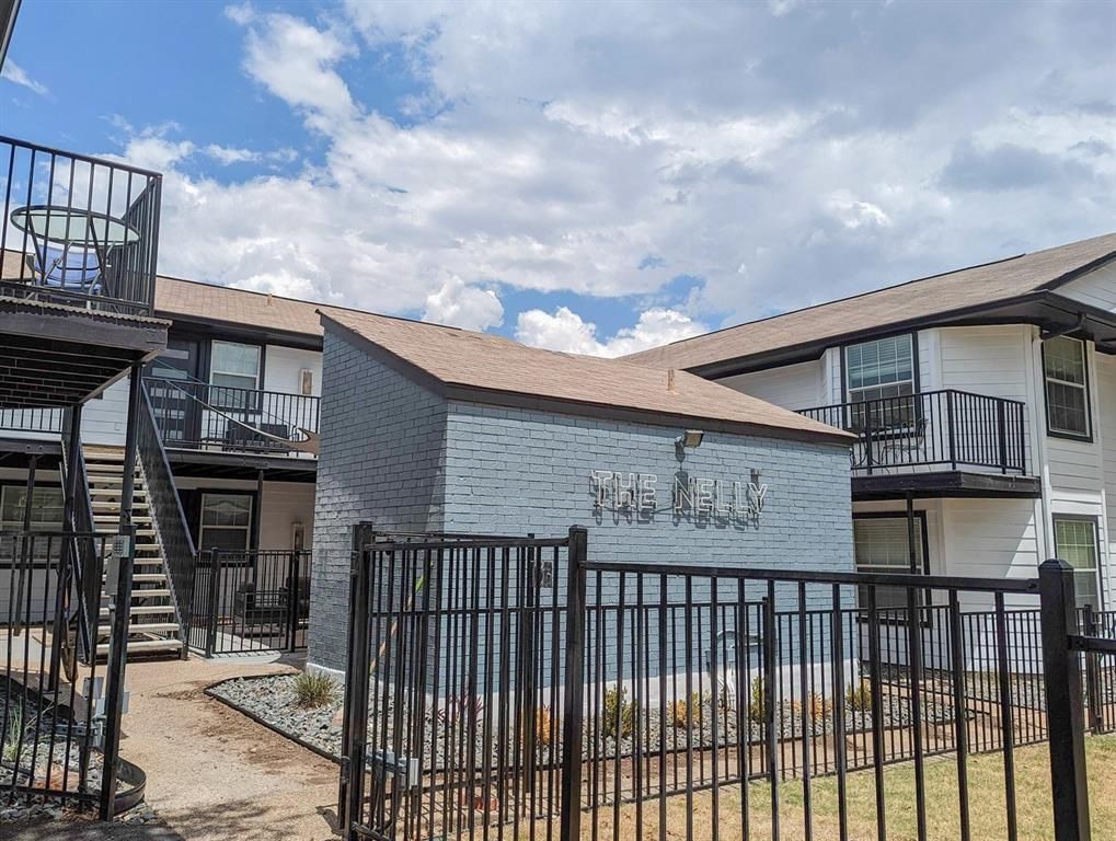 A building with stairs and a fence in front of it.