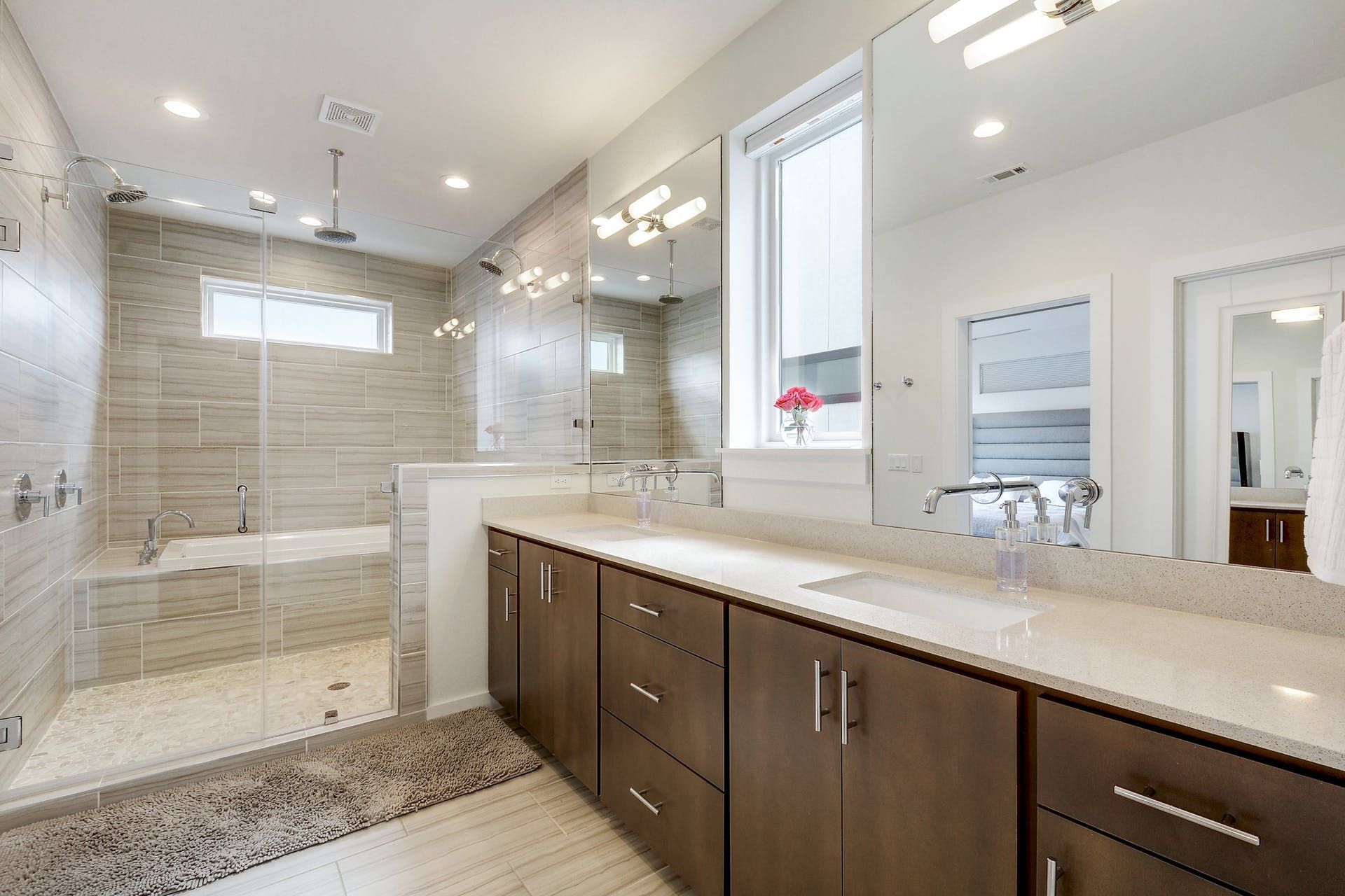 A bathroom with two sinks and a walk in shower.