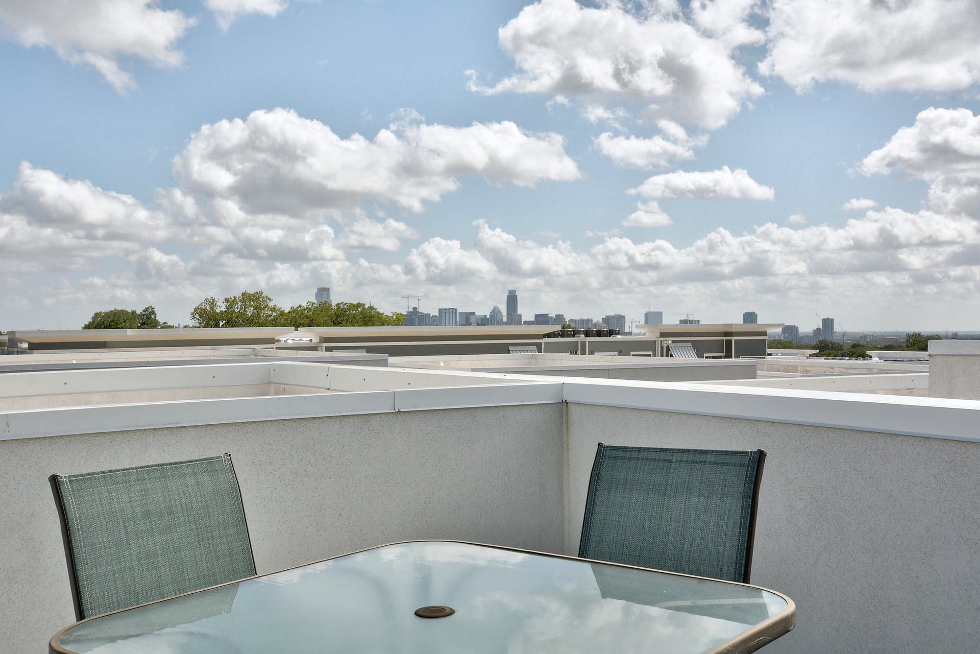A table and chairs on a balcony overlooking a city