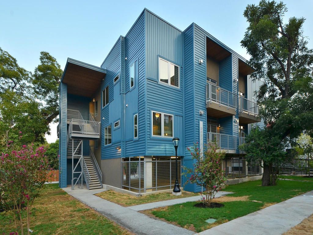 A blue apartment building with stairs leading up to the second floor