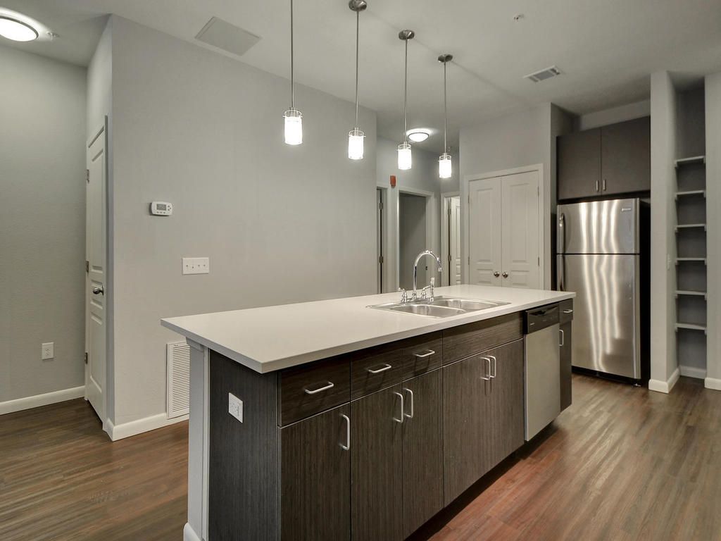 A kitchen with a large island and stainless steel appliances.