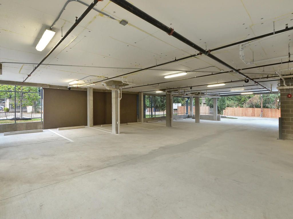 An empty parking garage with a lot of lights on the ceiling.
