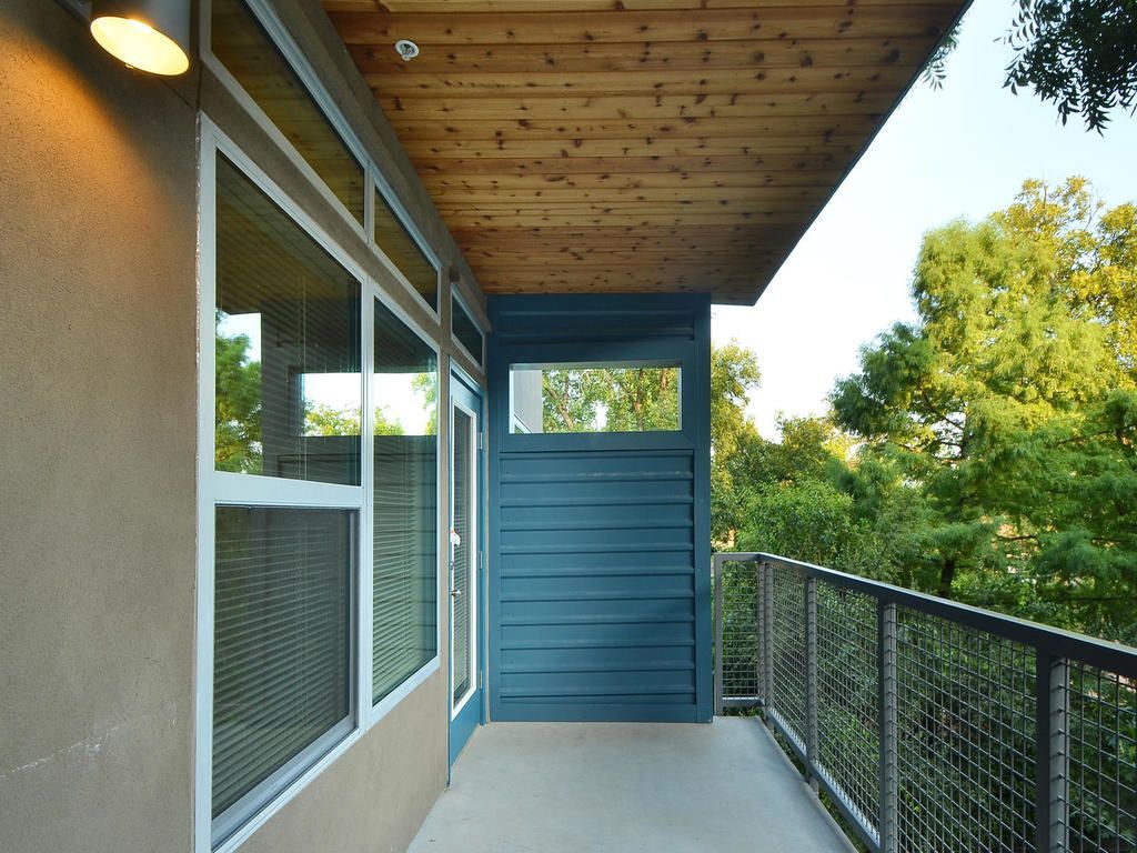 A balcony with a wooden ceiling and a fence