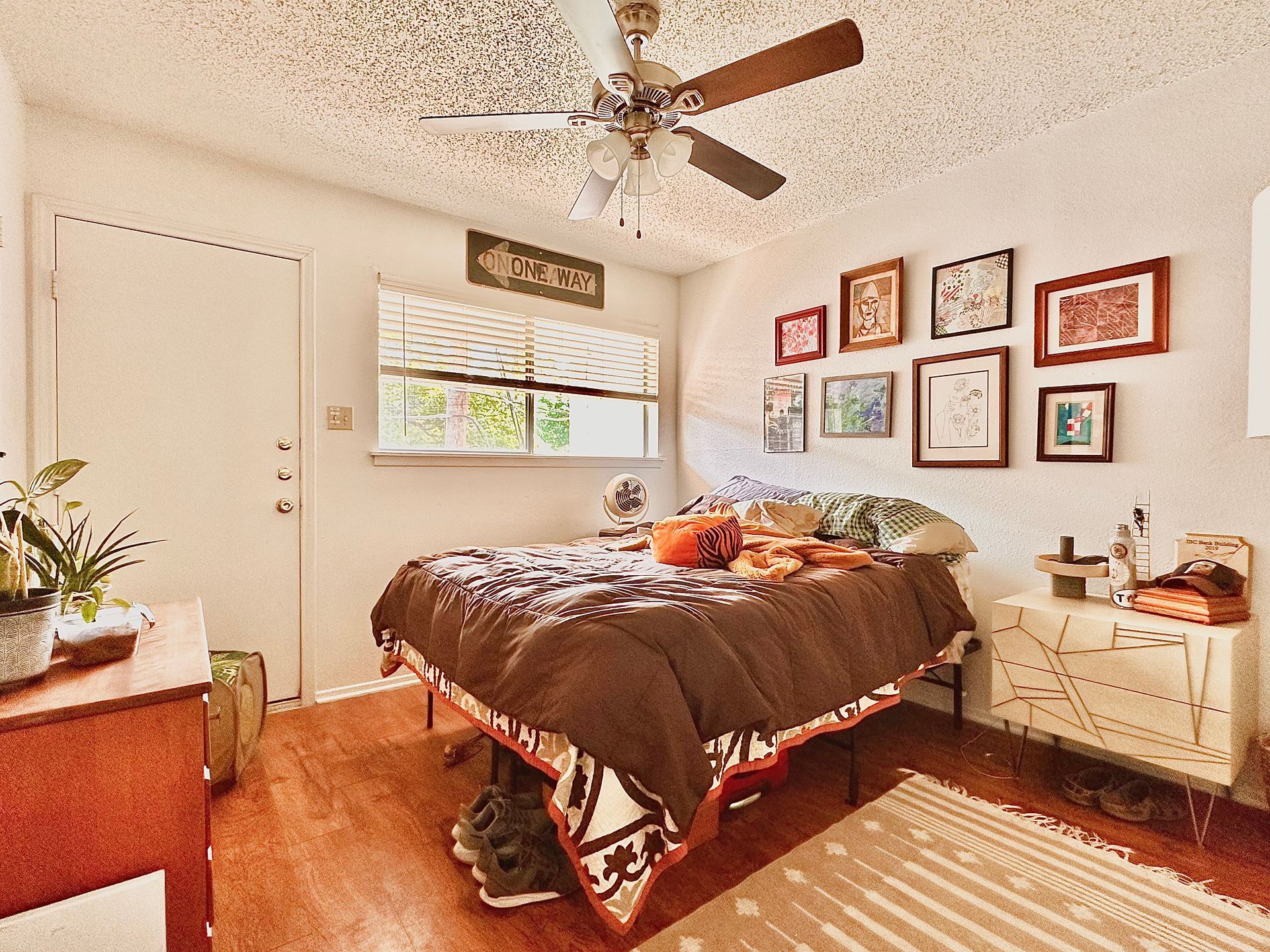A bedroom with a bed and a ceiling fan