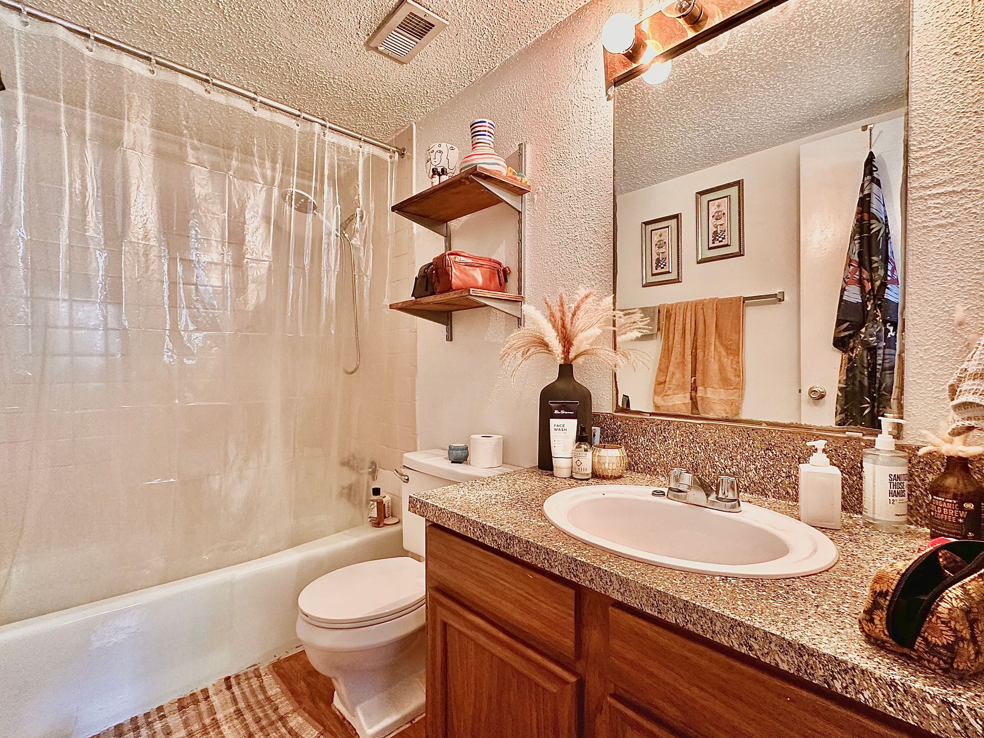 A bathroom with a sink , toilet , tub and mirror.