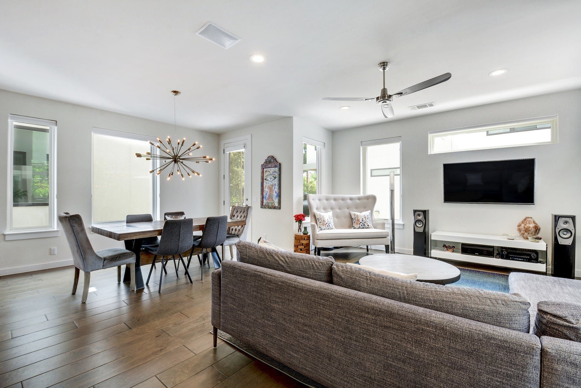 A living room with a couch , chairs , table and television.