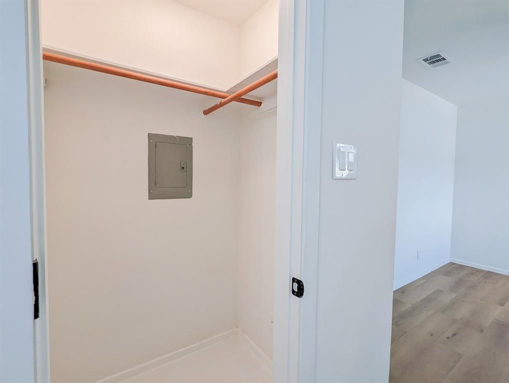 A walk in closet in a house with a light switch on the wall.