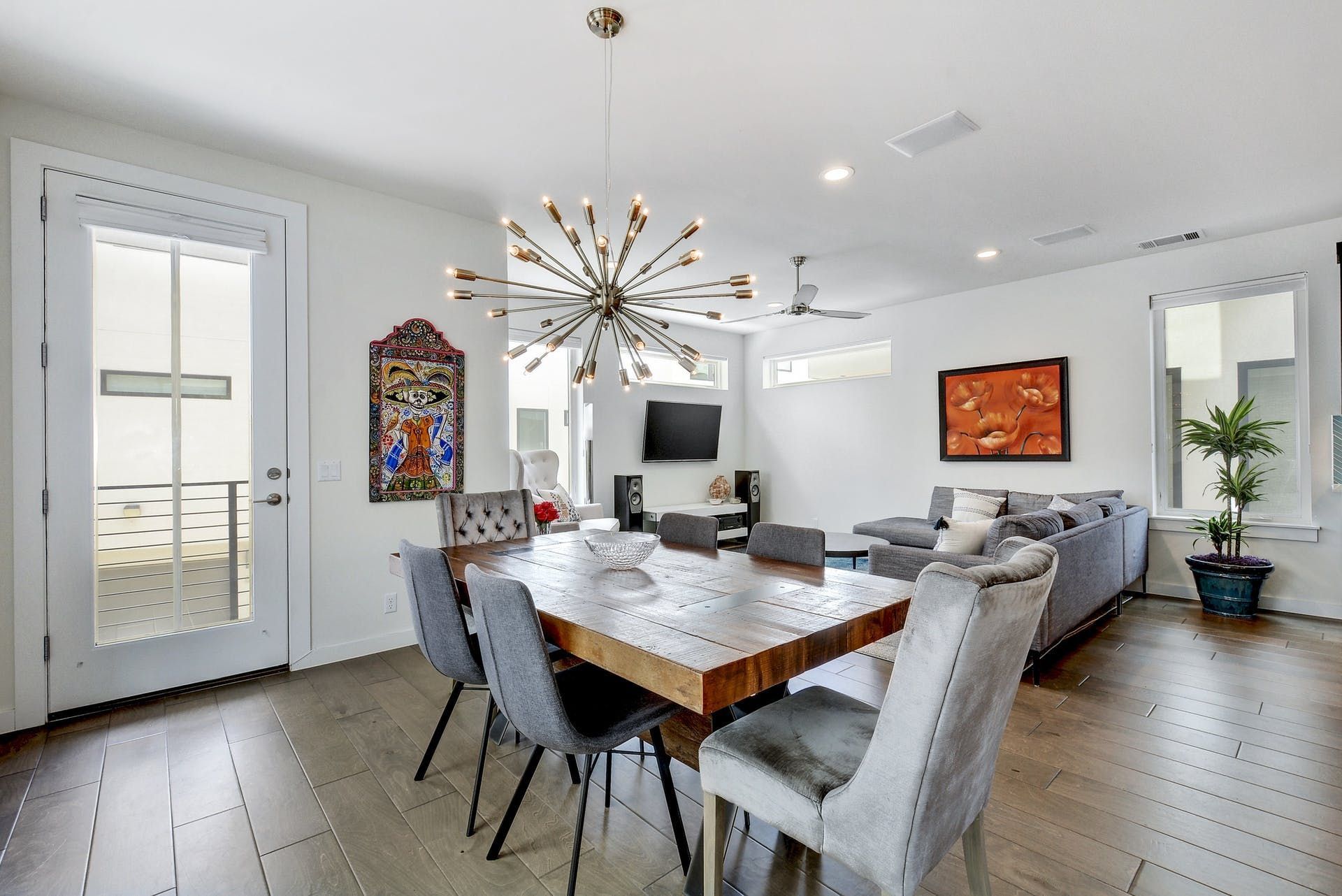 A dining room with a table and chairs and a chandelier hanging from the ceiling.