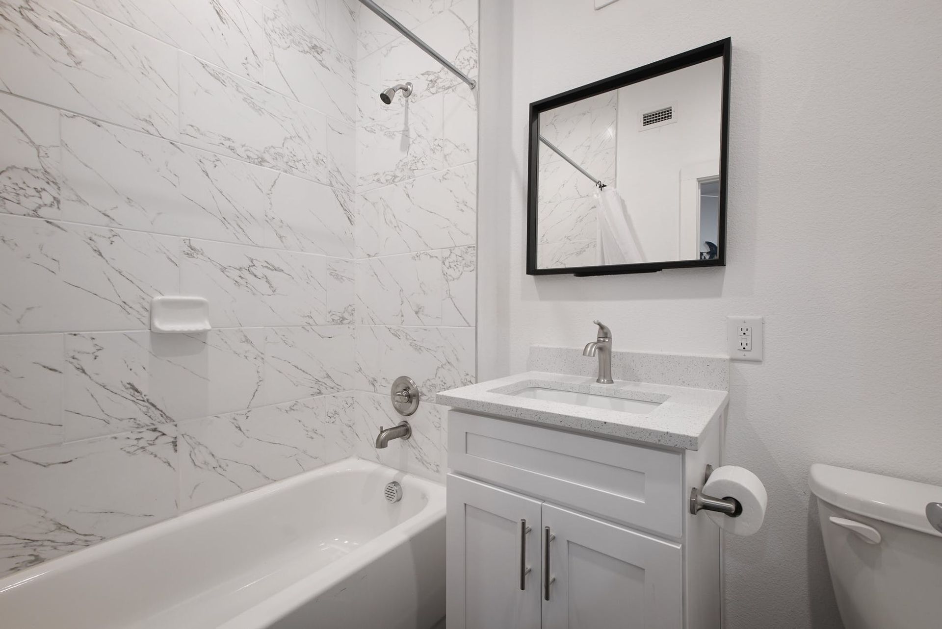 A bathroom with a tub , sink and mirror