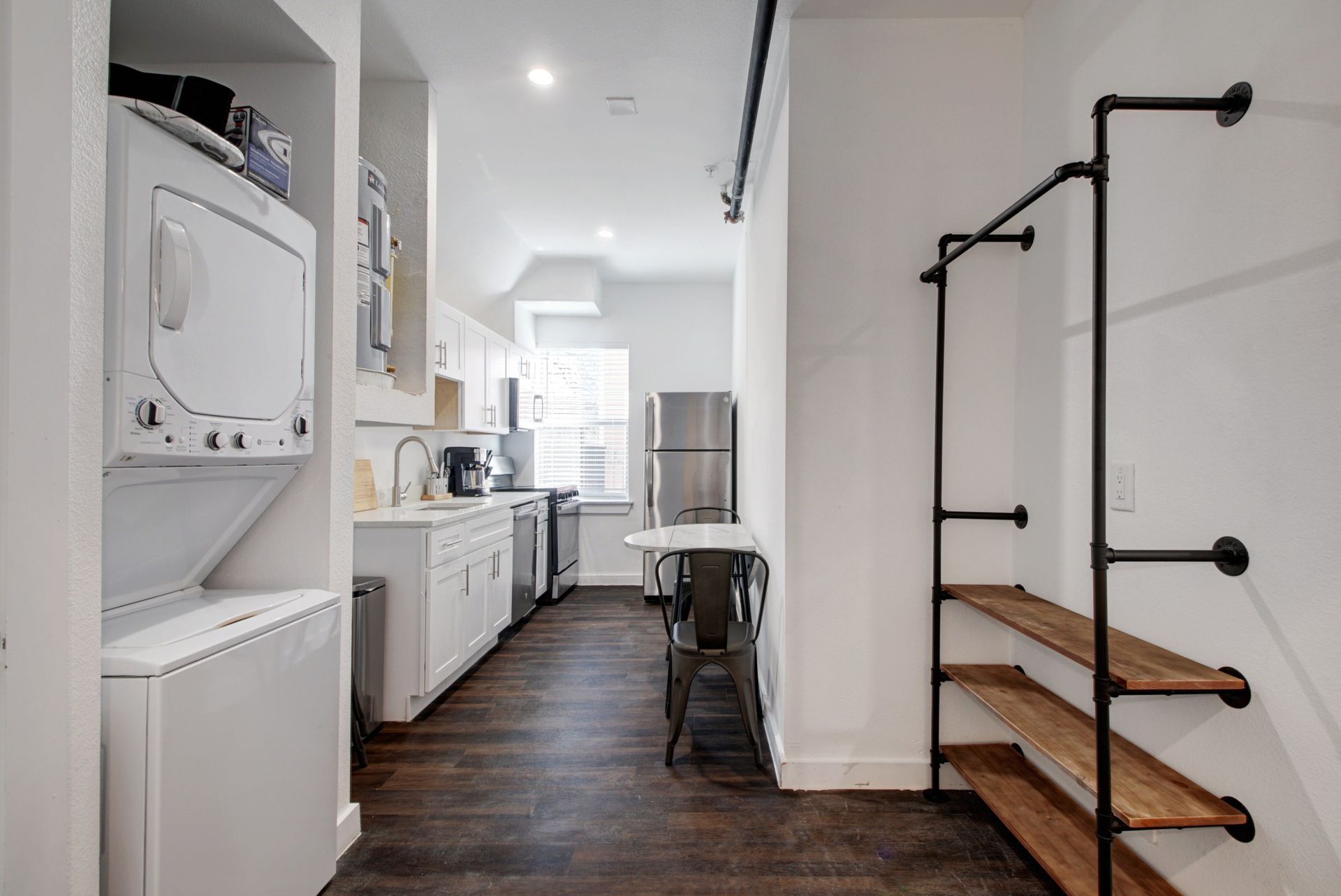 A kitchen with a washer and dryer stacked on top of each other.