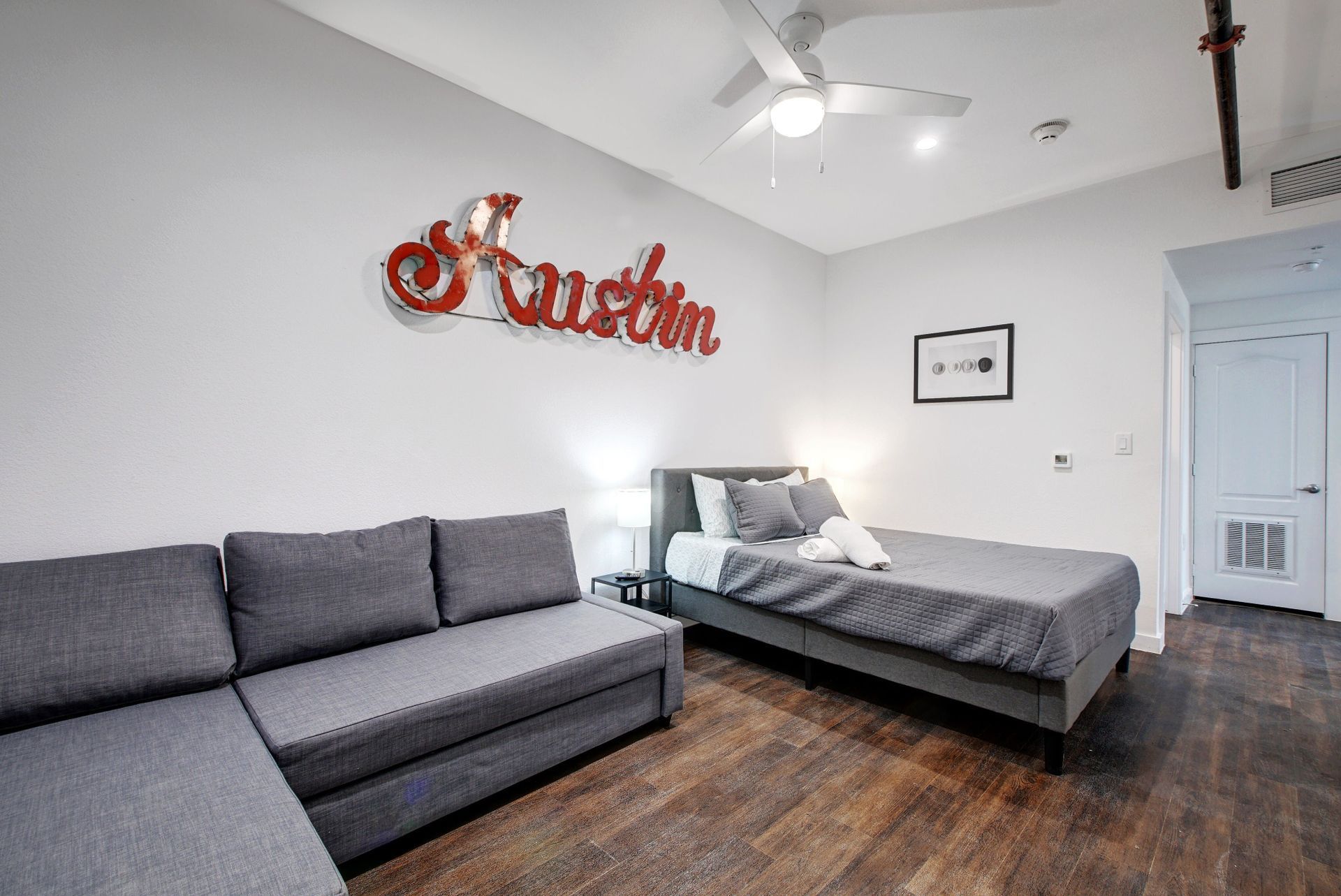 A bedroom with a bed , couch , and ceiling fan.