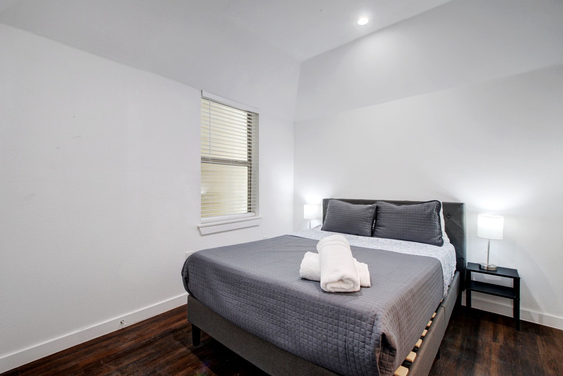 A bedroom with a king size bed and a window.