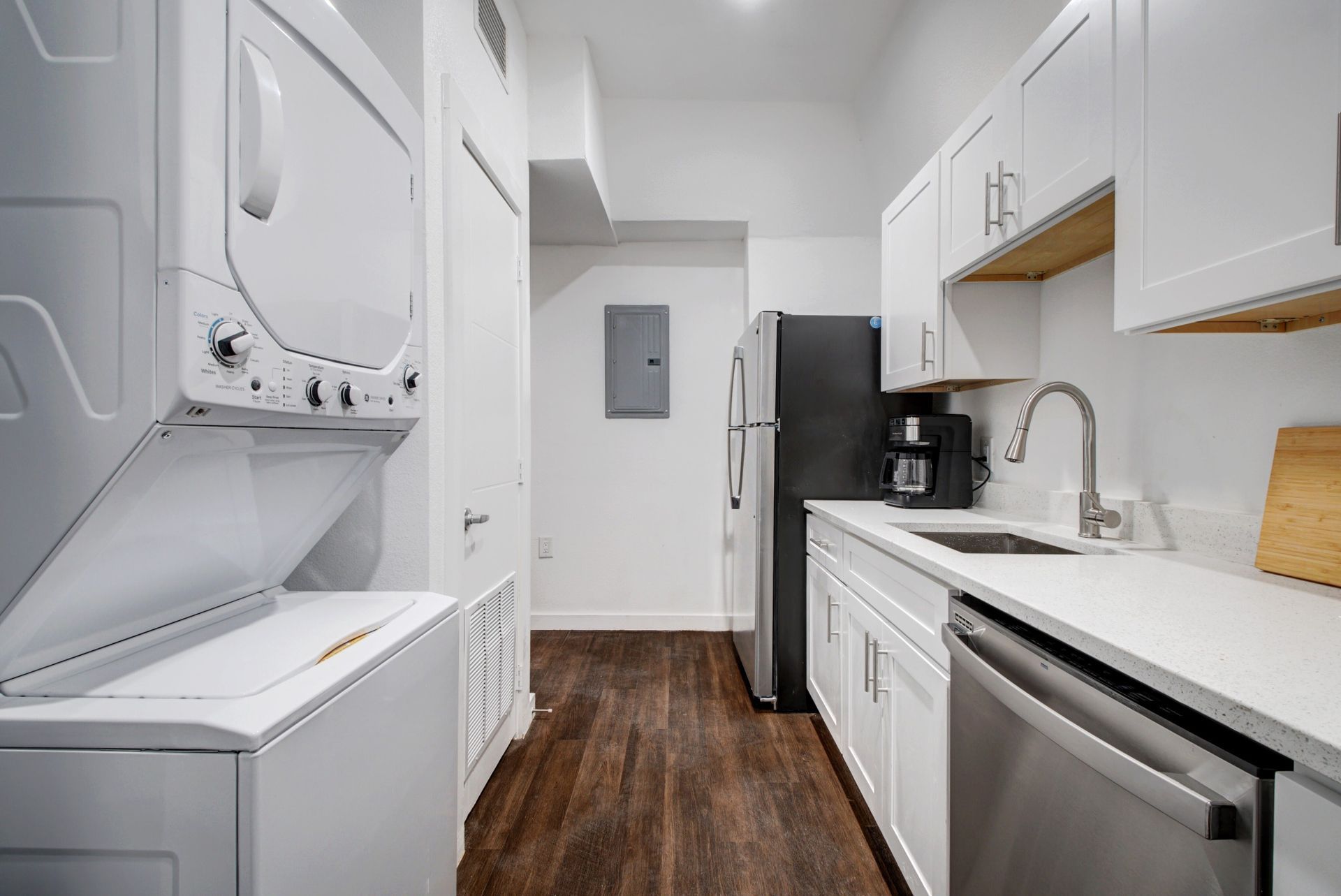 A kitchen with a washer and dryer stacked on top of each other.