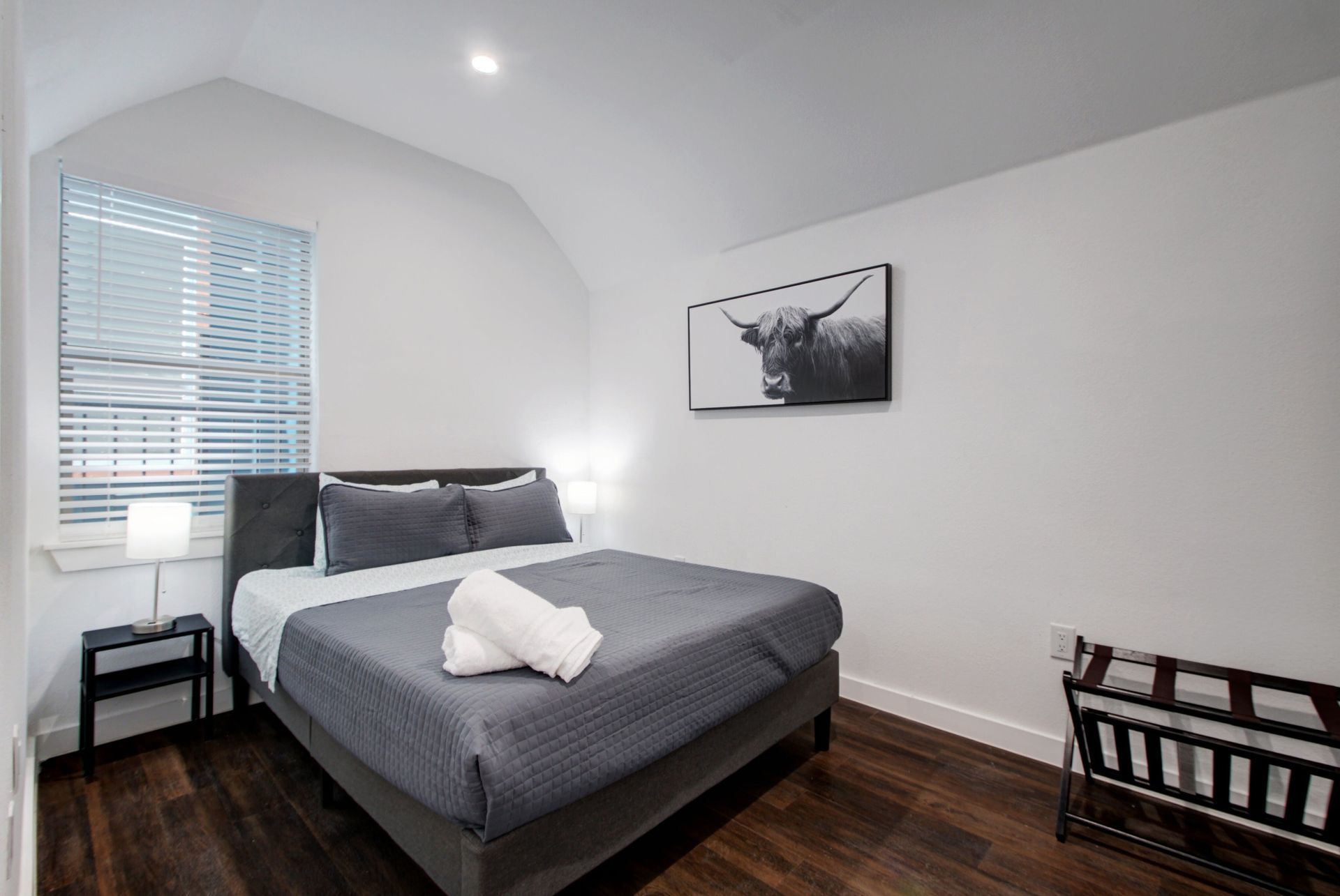 A bedroom with a large bed and a picture of a bull on the wall.