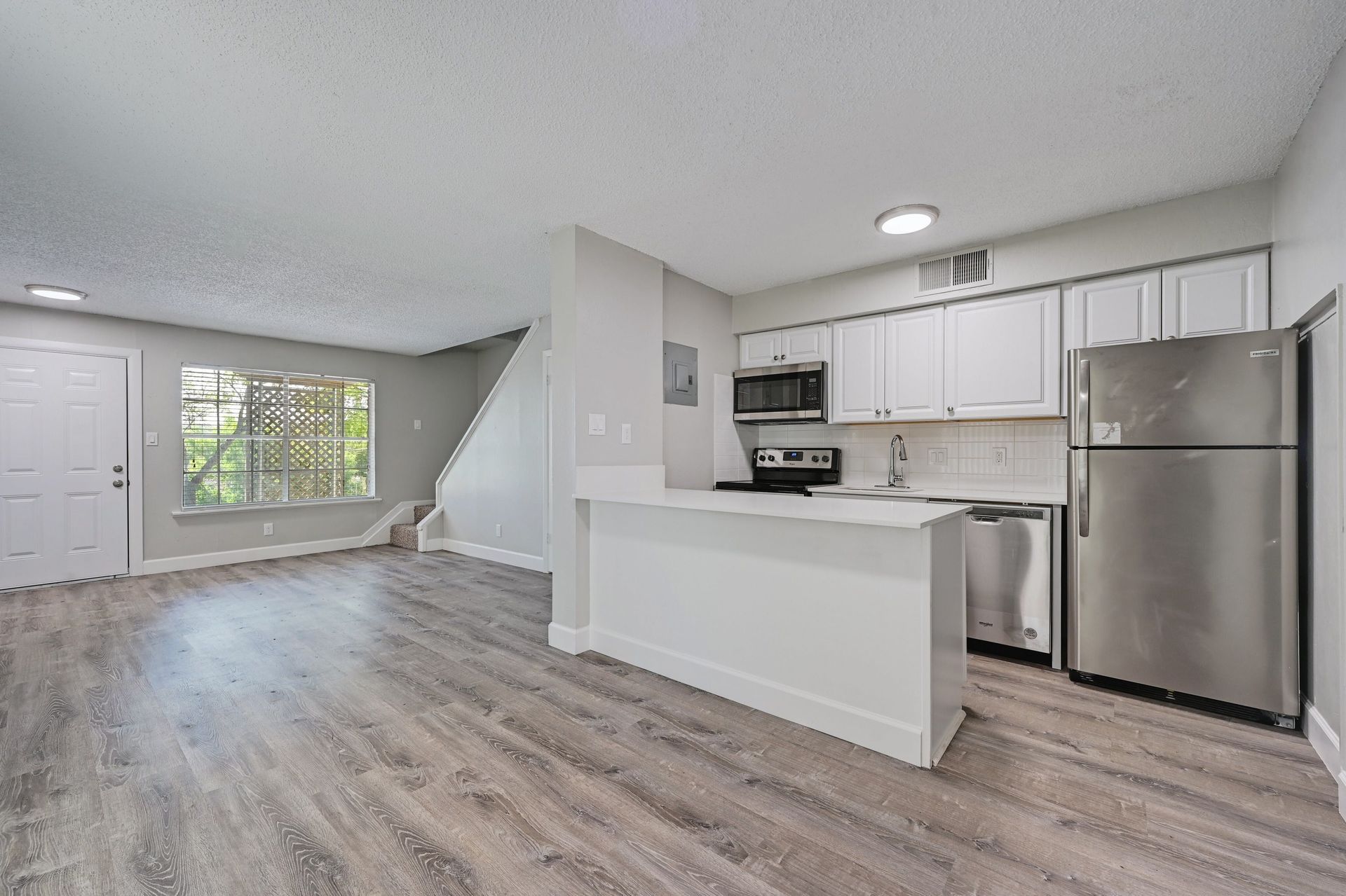 A kitchen with stainless steel appliances and white cabinets