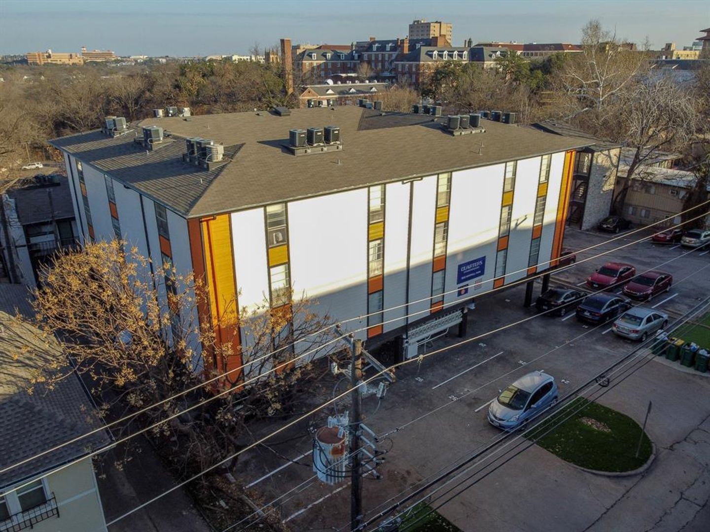 An aerial view of a large building with cars parked in front of it.