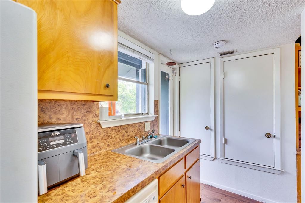 A kitchen with two sinks , a refrigerator , and a window.