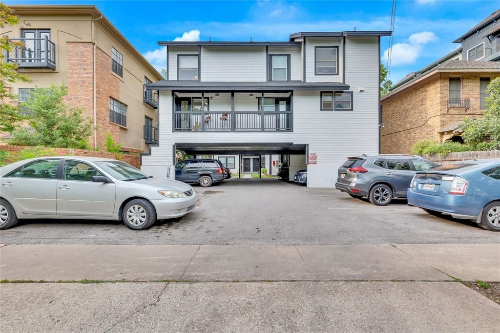 A white building with cars parked in front of it.