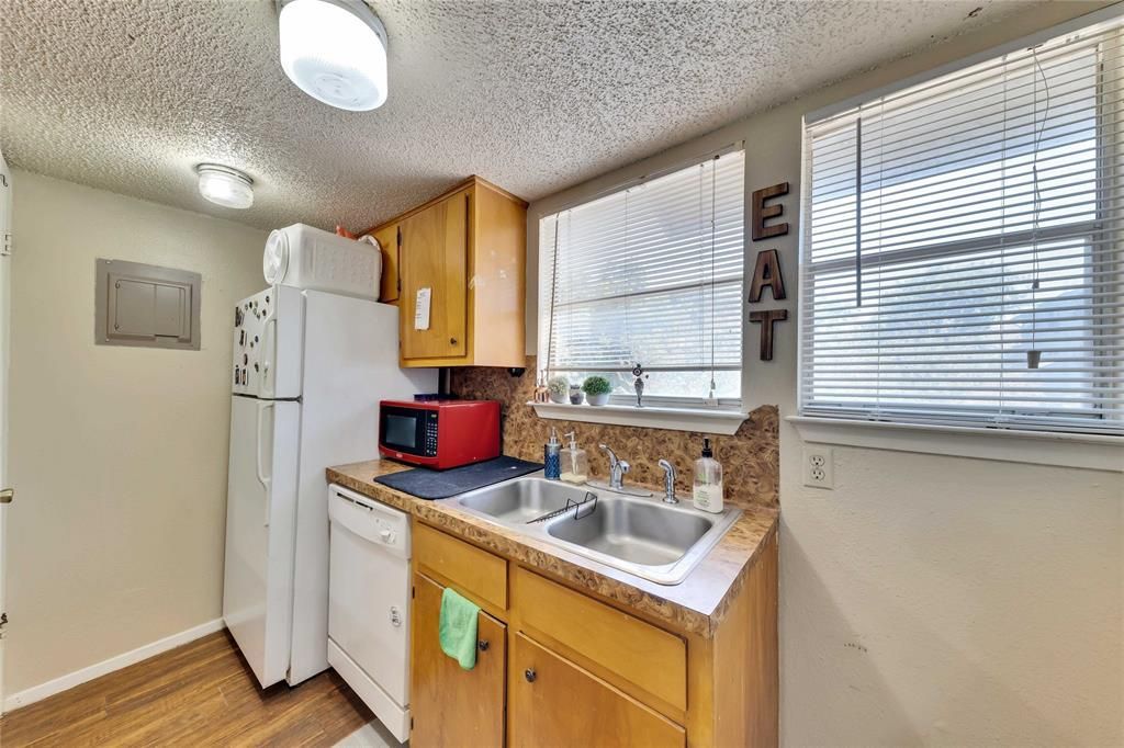 A kitchen with a sink , refrigerator , dishwasher and microwave.