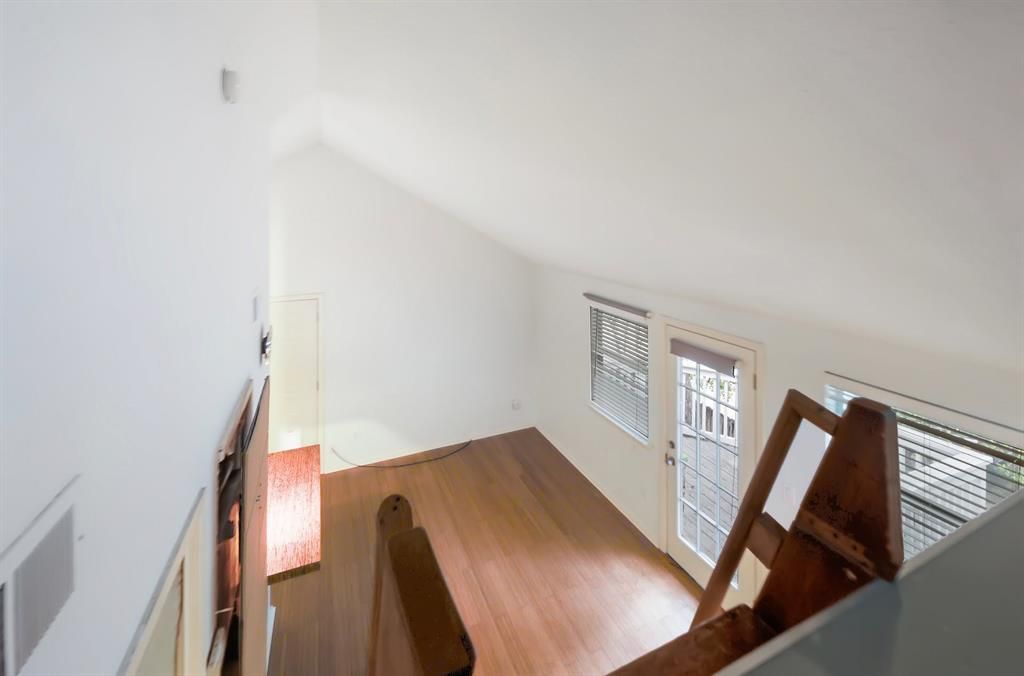 An aerial view of a living room with hardwood floors and white walls