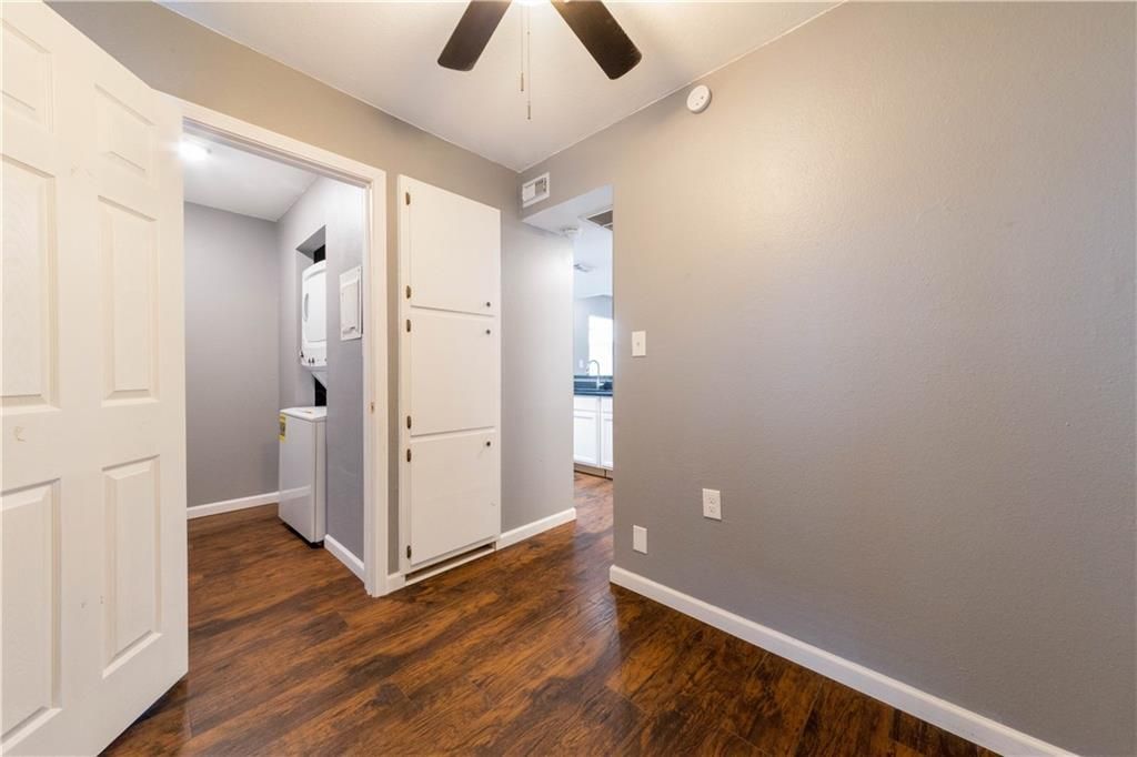 An empty room with hardwood floors and a ceiling fan.