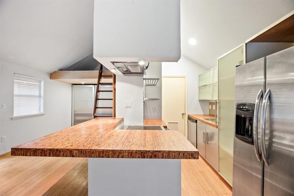 A kitchen with stainless steel appliances and a wooden counter top