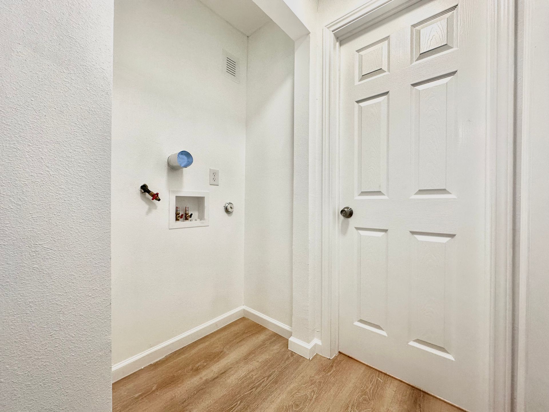 A laundry room with a washer and dryer and a door.