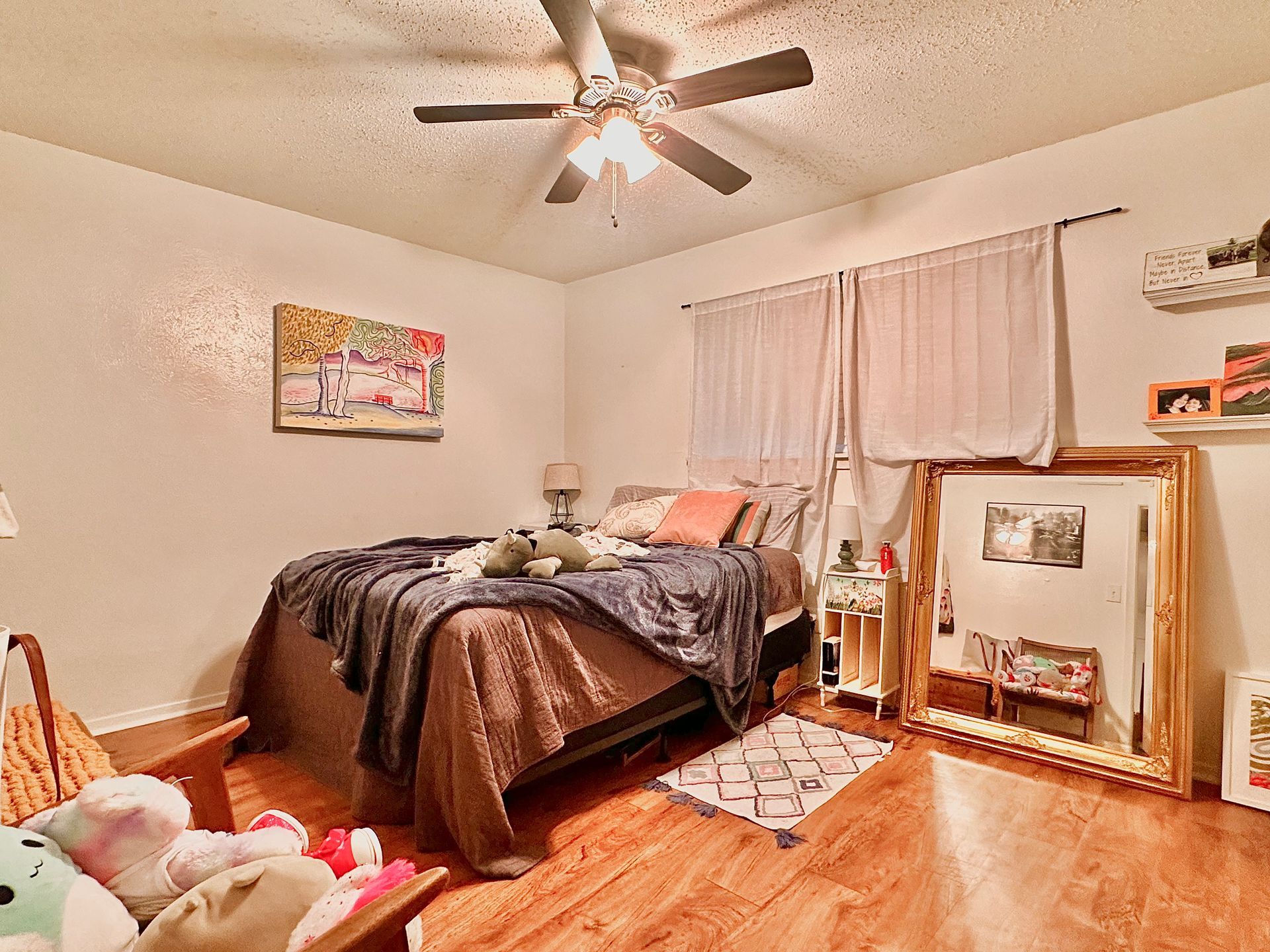 A bedroom with a bed and a ceiling fan.