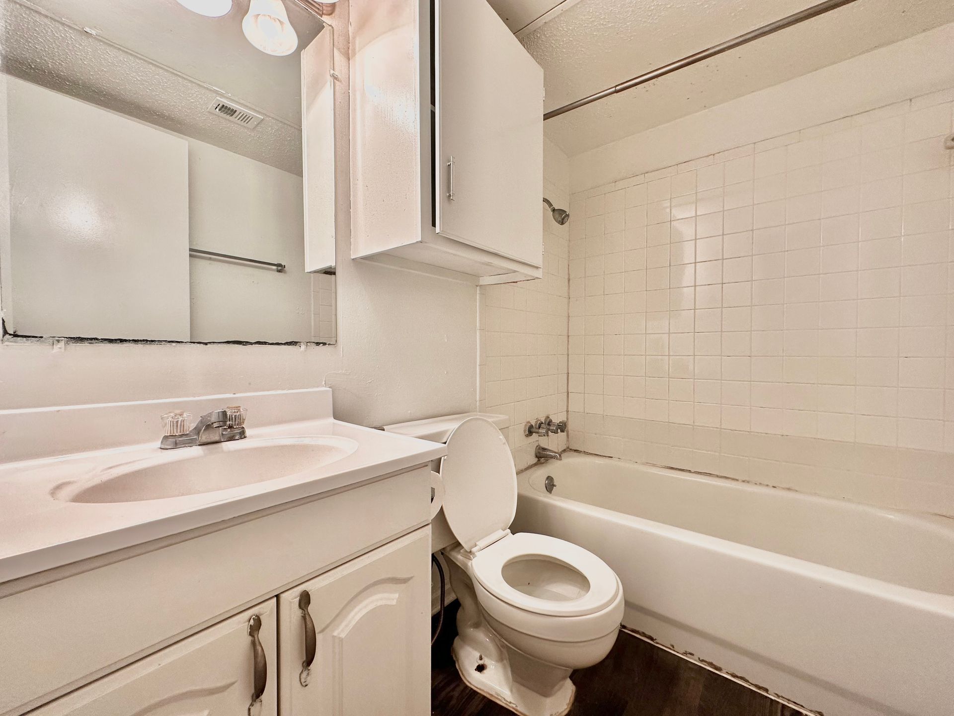A bathroom with a toilet , sink and bathtub.